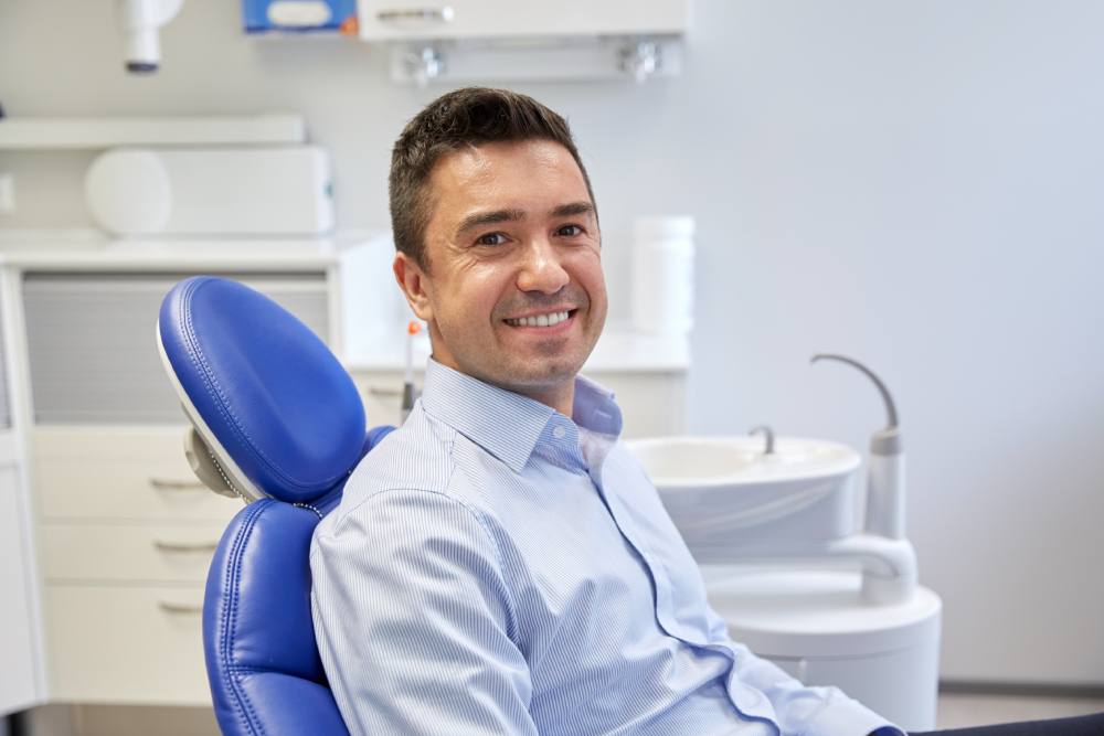 Smiling patient seated in a dental chair at a clinic accepting new patients in Windsor.
