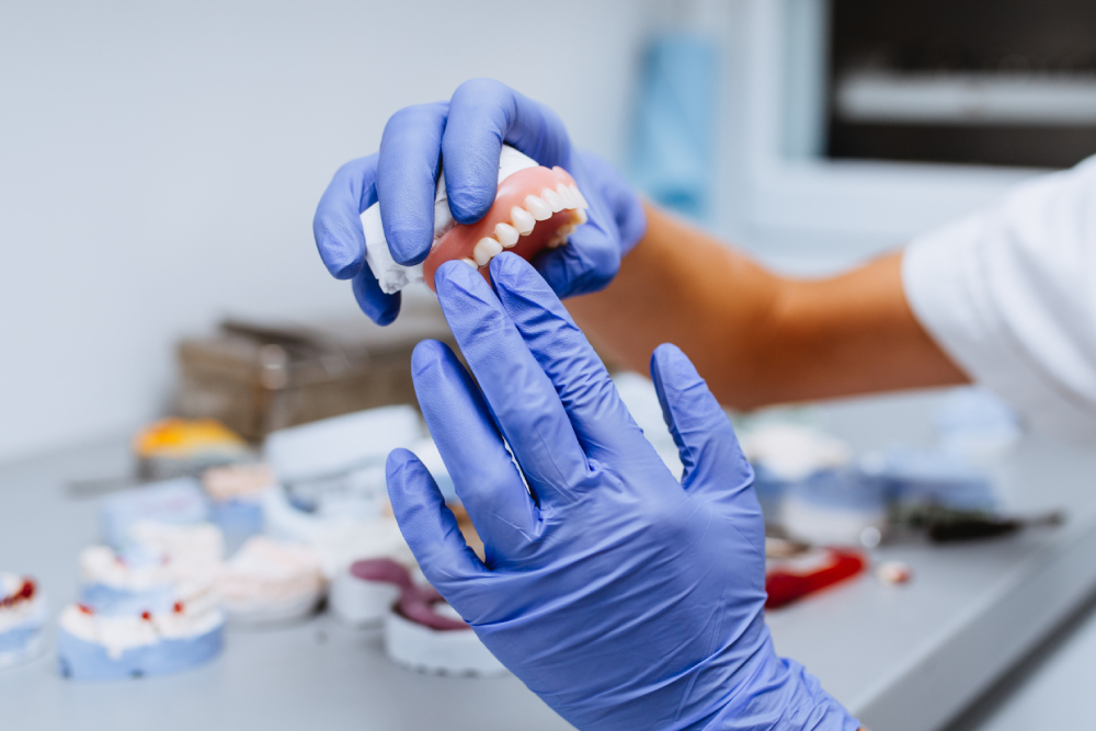 Dental professional examining custom dentures at a denture clinic in Windsor.