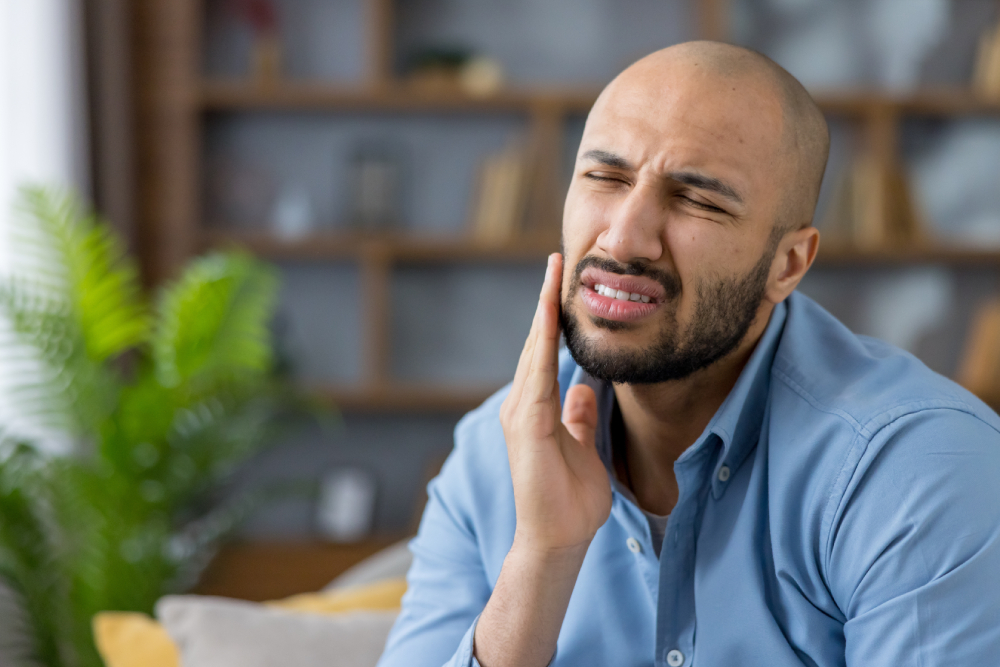 Man holding his jaw in pain, illustrating a severe toothache needing emergency dental care in Windsor.