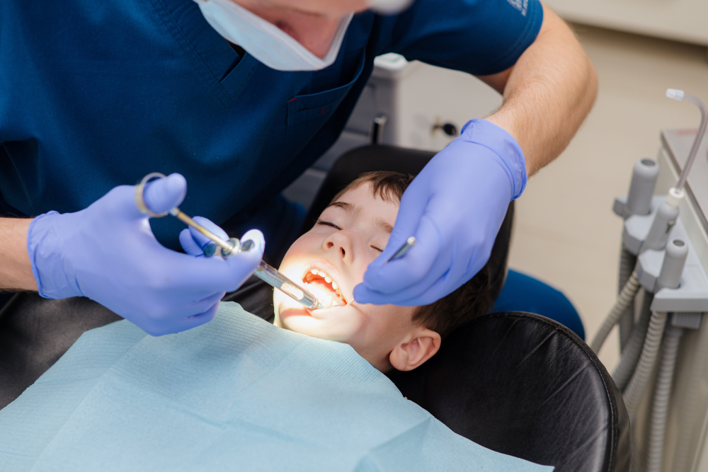 Emergency dentist in Windsor administering gentle care to a young child in a dental chair.